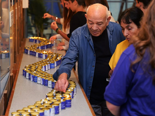 An elderly man lighting a memorial candle